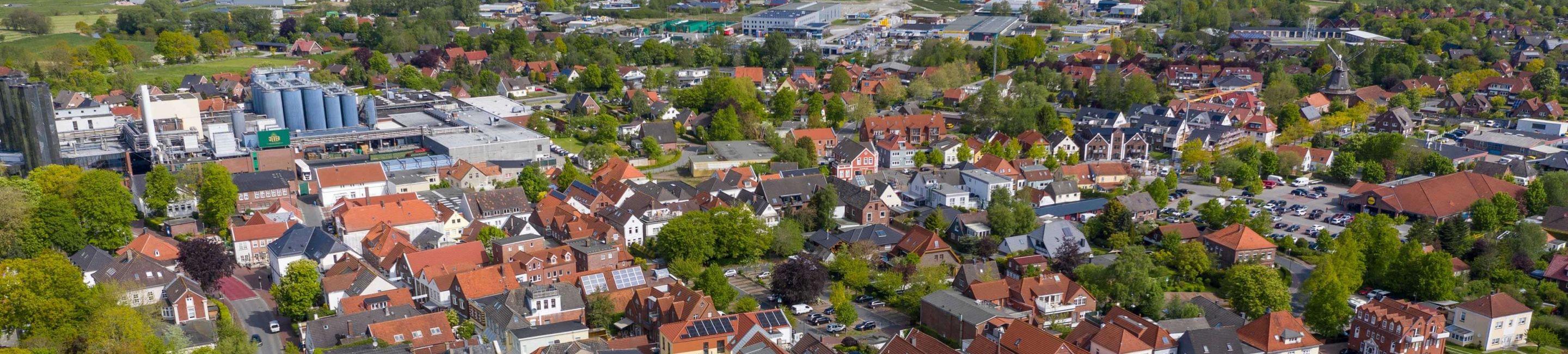 Foto aus der Höhe, man sieht den Alten Markt, das Gewerbegebiet im Hintergrund sowie Windkrafträder bis hin zur Nordsee